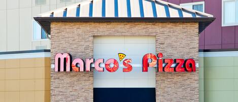 Un edificio con un letrero de Marco's Pizza.