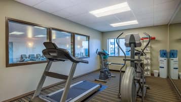 Gimnasio con cinta de correr, elíptica y bicicleta estática.