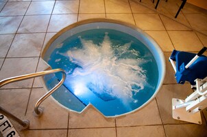 Une piscine équipée d’une échelle métallique et d’un appareil de nettoyage pour piscine.