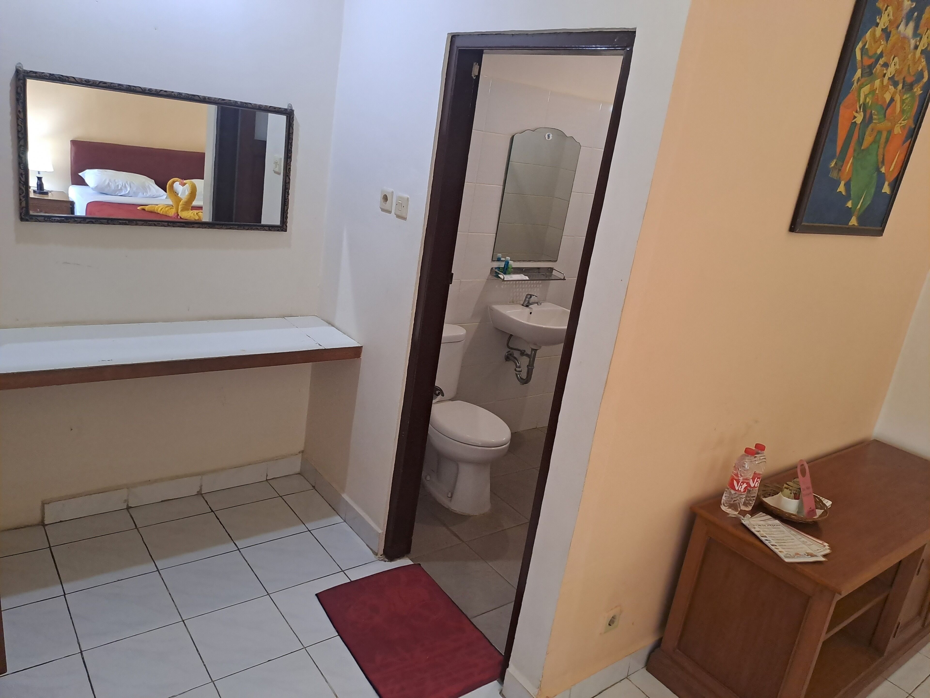Un baño de hotel con inodoro, lavabo y espejo.