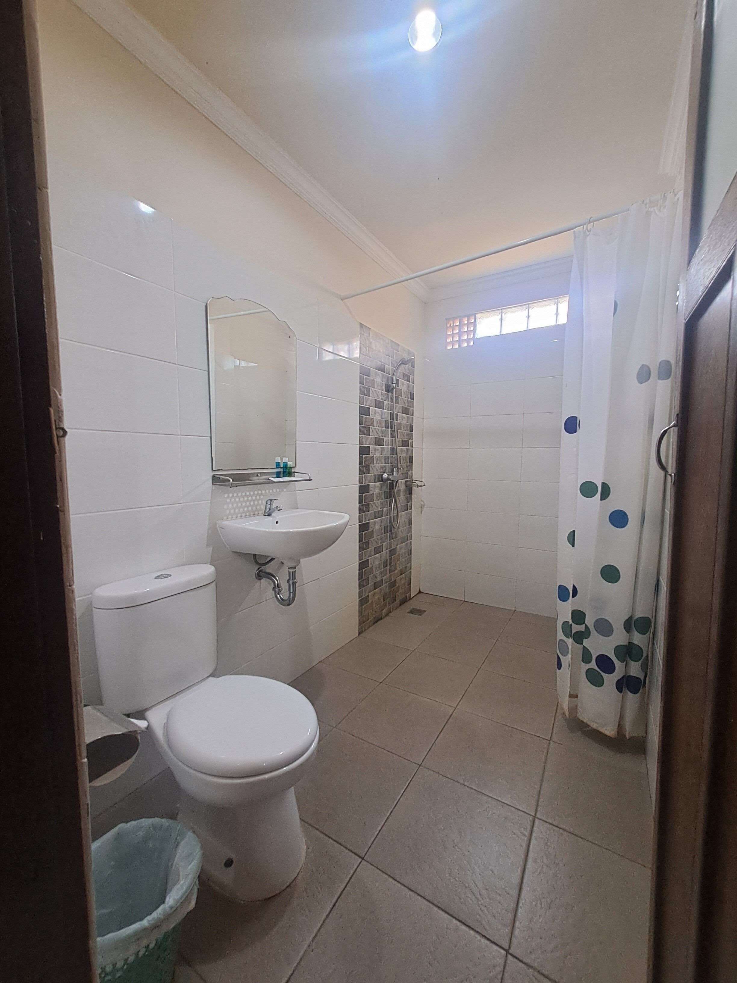 Un baño pequeño con inodoro, lavamanos y ducha.