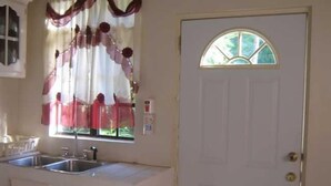 A kitchen with a window, a sink, and a door.