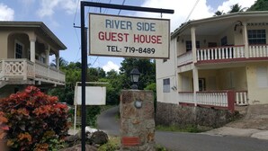 A sign for the River Side Guest House with a telephone number.