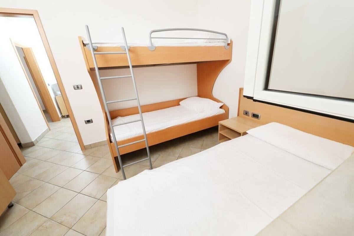 Habitación con literas, una cama individual y una ventana.