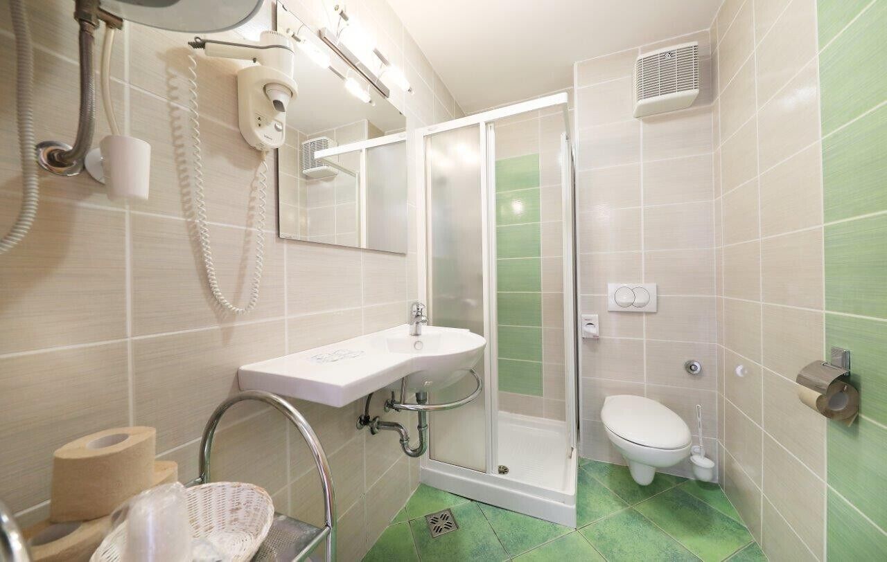 Une salle de bain équipée d’une douche, de toilettes, d’un lavabo et d’un téléphone.