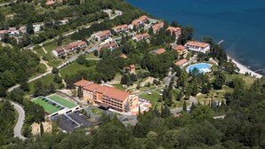 Vista aérea de una zona residencial costera con casas, una piscina y un campo deportivo.