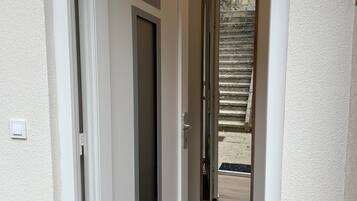 A hallway with a door labeled "718" leading to a room with a window.