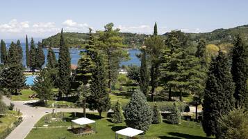 A park with picnic tables, a lake, and a distant view of houses.