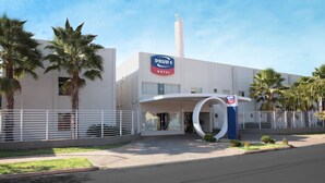A Drud's Hotel with a modern design, featuring a prominent entrance and a tall chimney. - Druds Hotel (Tres Lagoas)