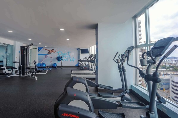 A gym with treadmills, exercise equipment, and a motivational poster. - Wyndham Guayaquil Puerto Santa Ana (Guayaquil)