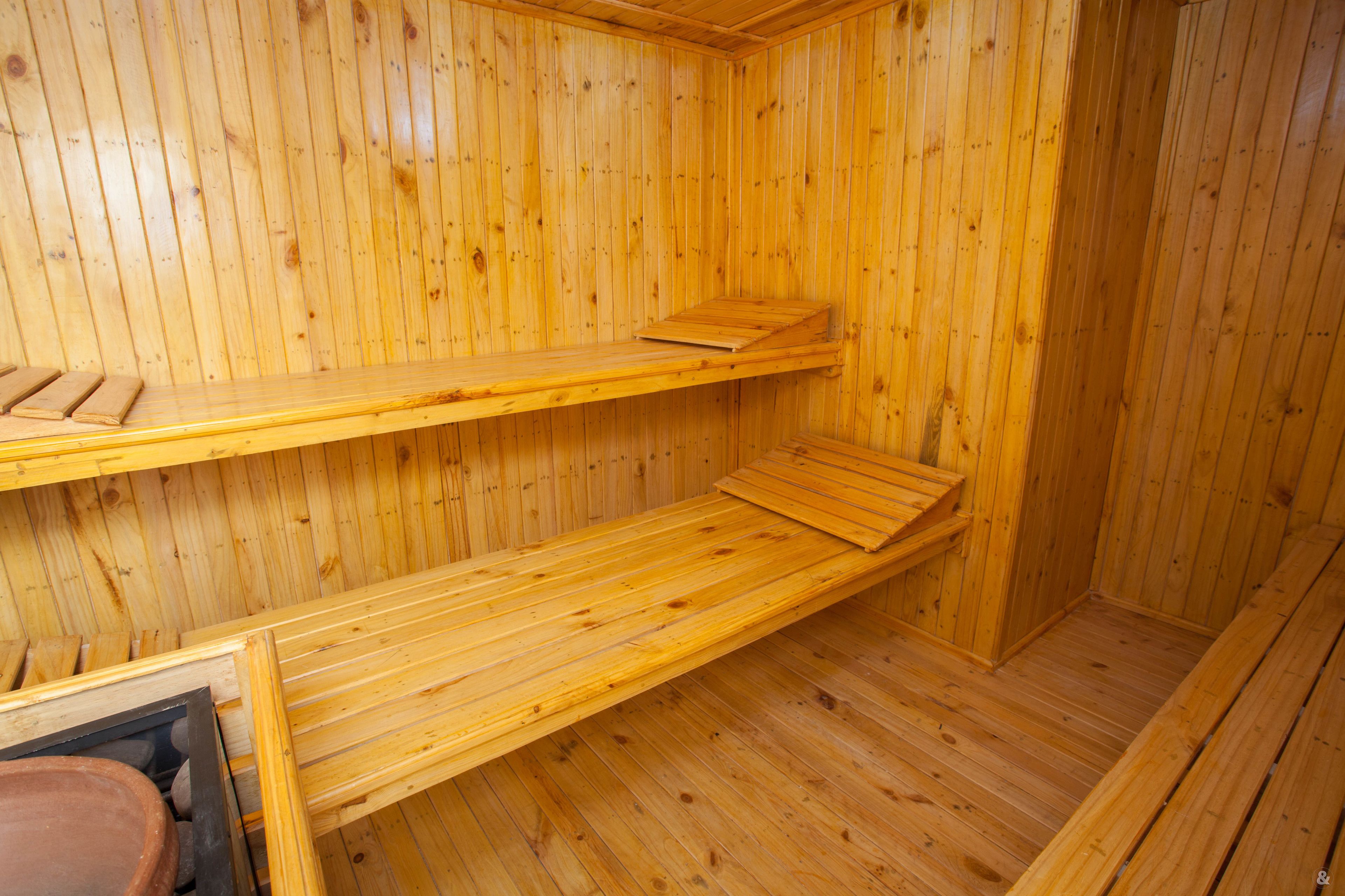 A wooden sauna with two benches and a bench on the floor.