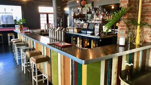 A bar area with a counter, stools, and a variety of bottles and glasses. - The Franklin Hotel (Adelaide)