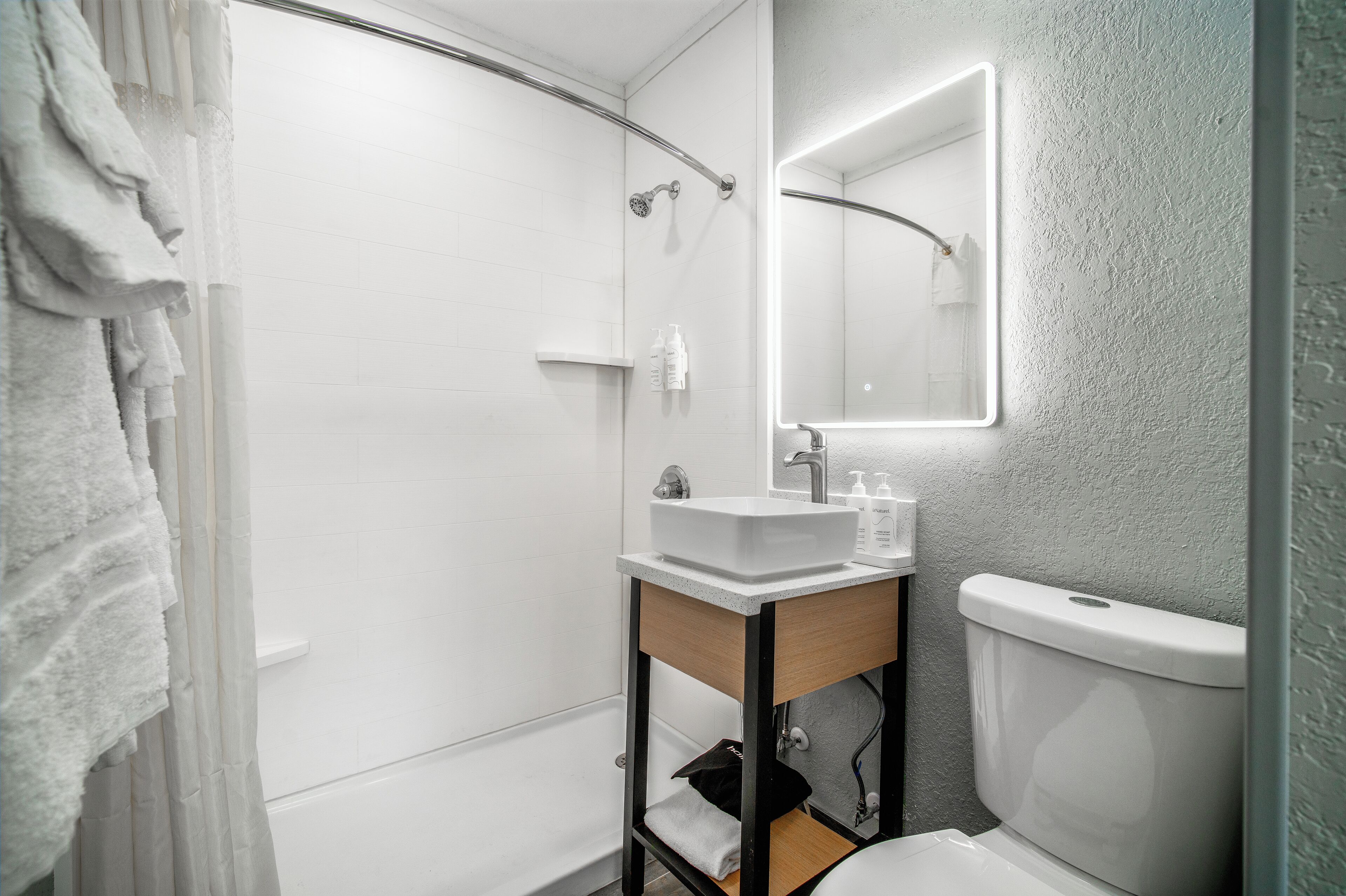 Une salle de bain moderne équipée d’une douche, de toilettes et d’un lavabo.