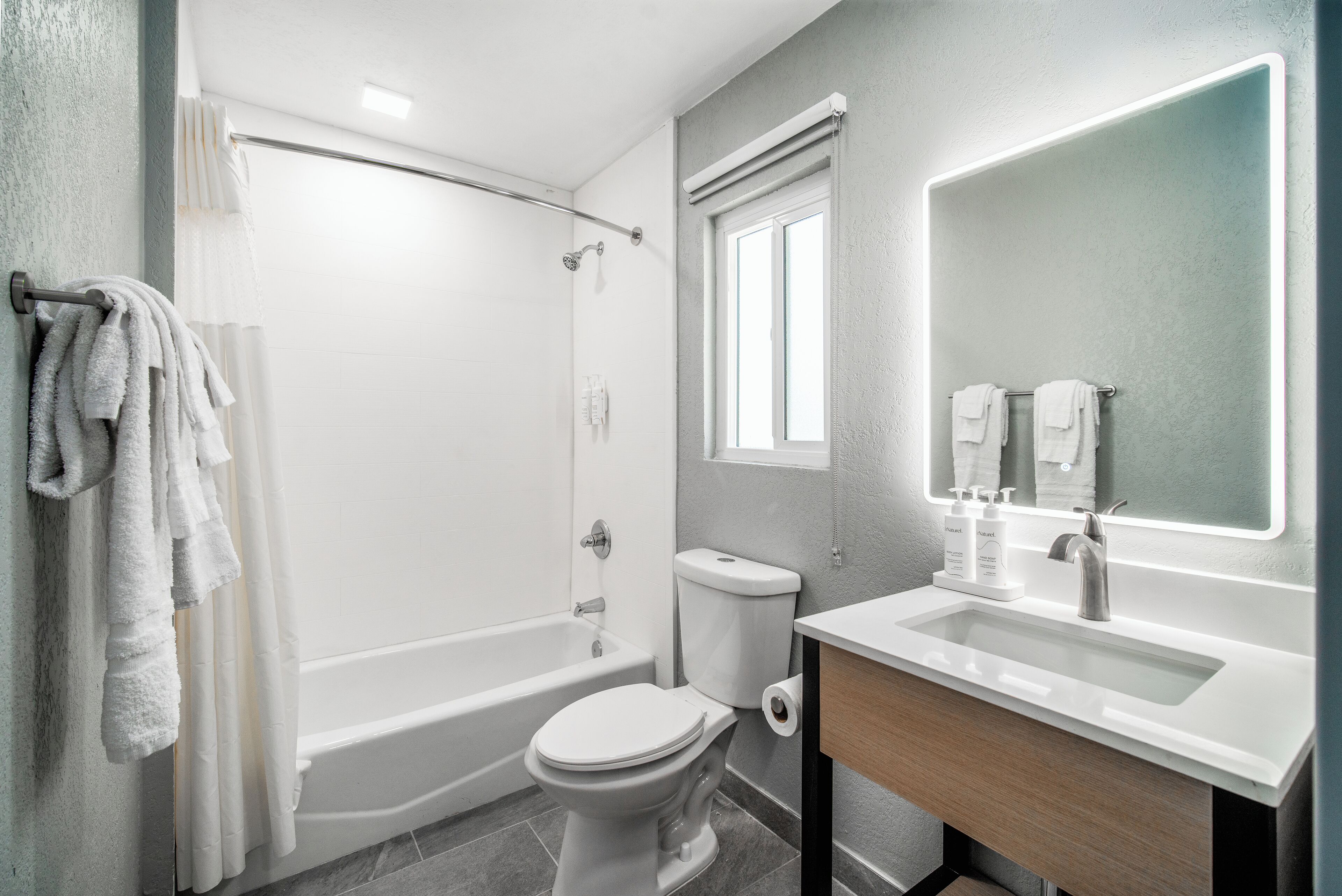 A modern bathroom with a bathtub, toilet, and sink.
