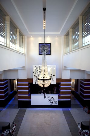 A lobby with a chandelier, a reception desk, and a staircase. - Grand Park Hotel (Ramallah)