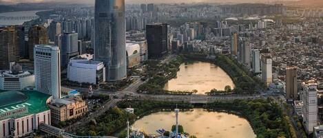 A cityscape with a prominent skyscraper, a river, and a theme park.