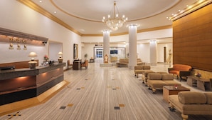 A spacious lobby with a reception desk, comfortable seating, and a chandelier. - Sangam Hotel in Thanjavur (Thanjavur)