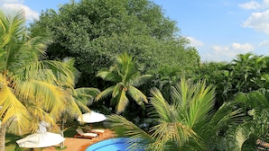 A swimming pool surrounded by palm trees and greenery, with a 'No Diving' sign visible. - Sangam Hotel in Thanjavur (Thanjavur)