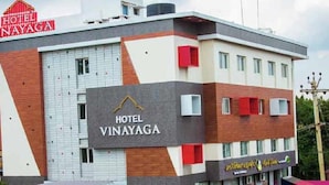 A hotel named 'HOTEL VINAYAGA' with a modern architectural design, featuring a prominent sign and a visible entrance.