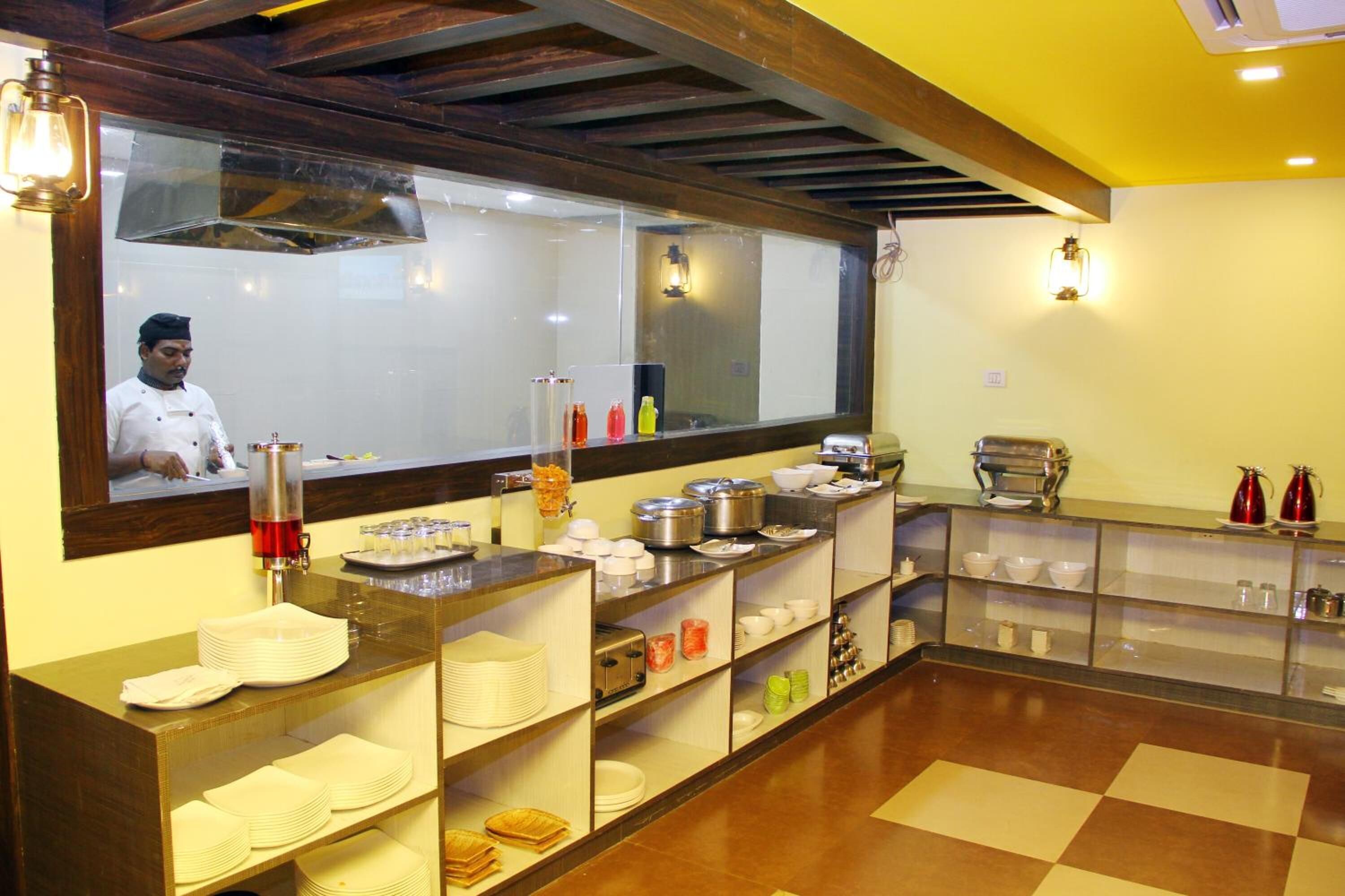 A buffet setup with various food containers, plates, and serving utensils.