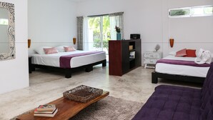 A hotel room with two beds, a wooden coffee table, a bookshelf, and a large window with curtains. - Villas H2O (Tulum)