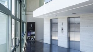 A modern interior with a glass facade, a mezzanine level, and a clean, tiled floor. - Hotel Spark Antofagasta (Antofagasta)