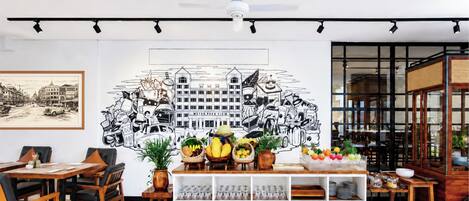 Un comedor moderno con un mural, muebles de madera y un panel de vidrio.