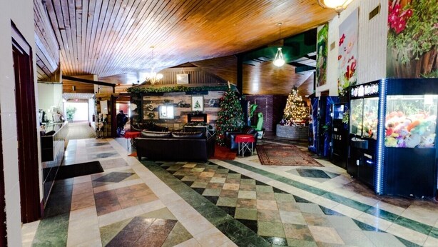 A lobby with a check-in counter, a Christmas tree, and vending machines. - Vegreville Garden Inn (Vegreville)