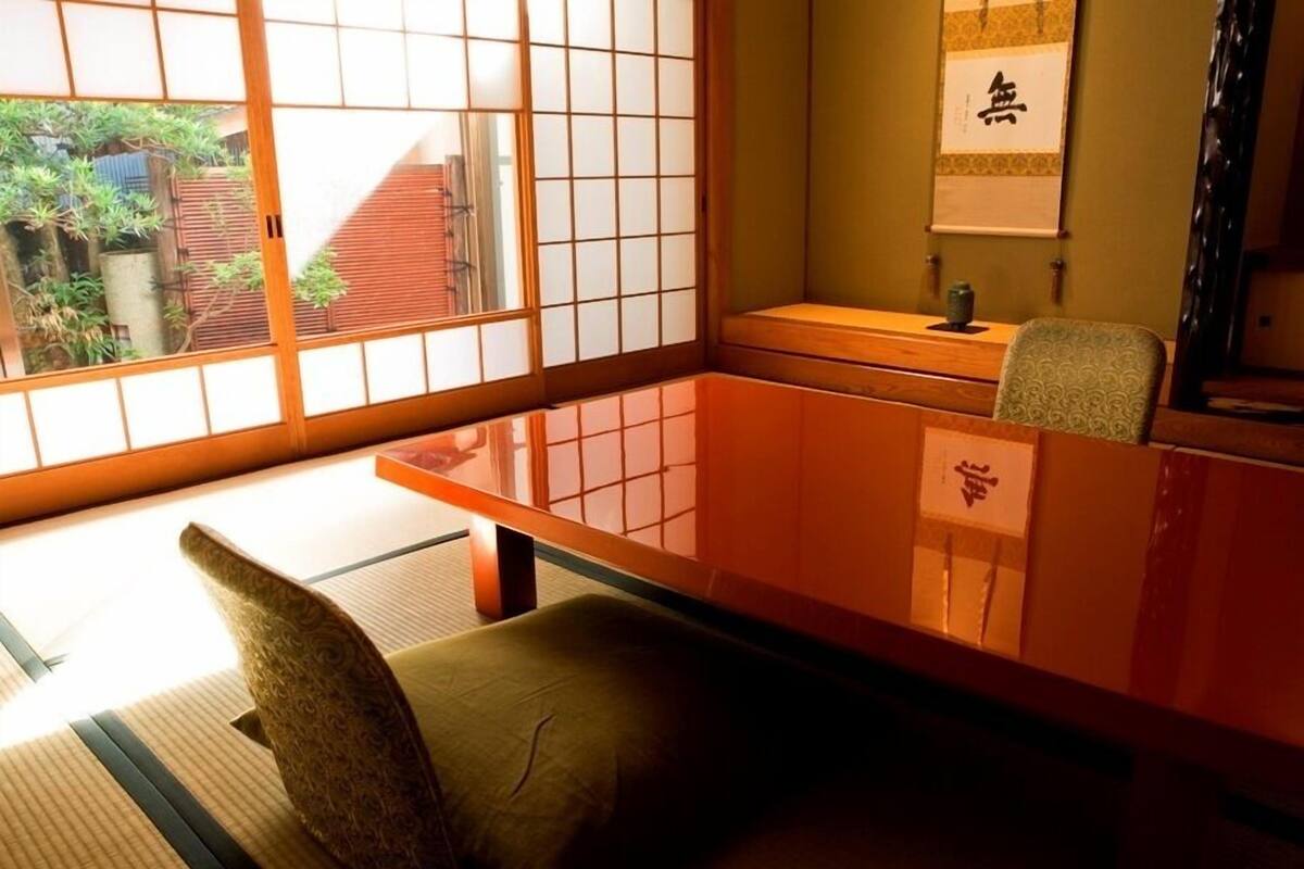 Une pièce de style japonais traditionnel, avec un sol recouvert de tatamis, une table basse et une porte coulissante.