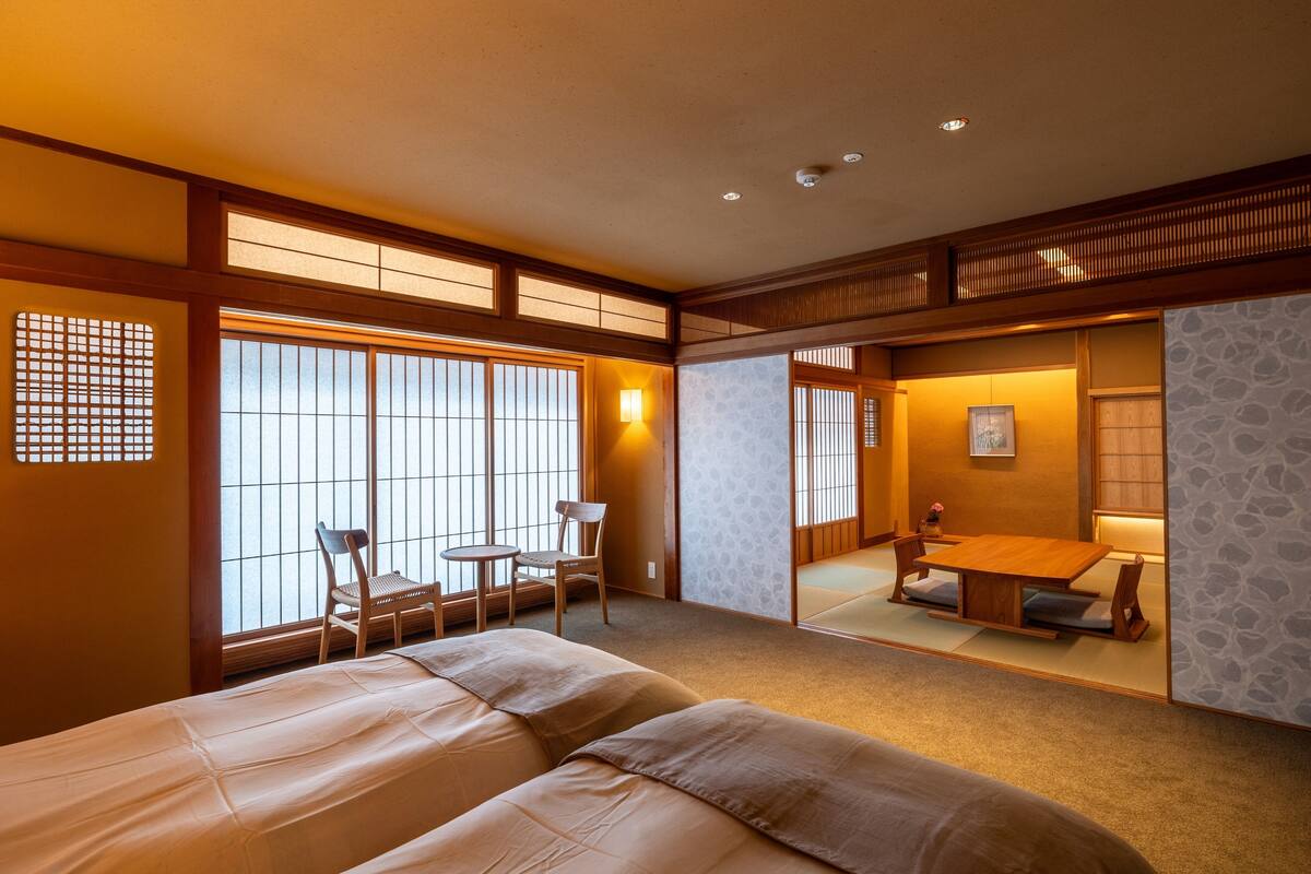 Une pièce de style japonais traditionnel, avec un sol recouvert de tatamis, une basse table en bois et une porte coulissante.