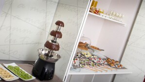 A buffet with various food items, including a chocolate fountain and sliced fruits. - Hotel Santa Brigida (Naples)