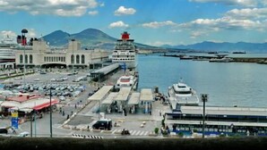 A cruise ship docked at a port with a mountainous backdrop and a clear sky. - Hotel Santa Brigida (Naples)