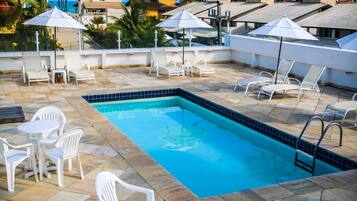 Alberca al aire libre y camastros