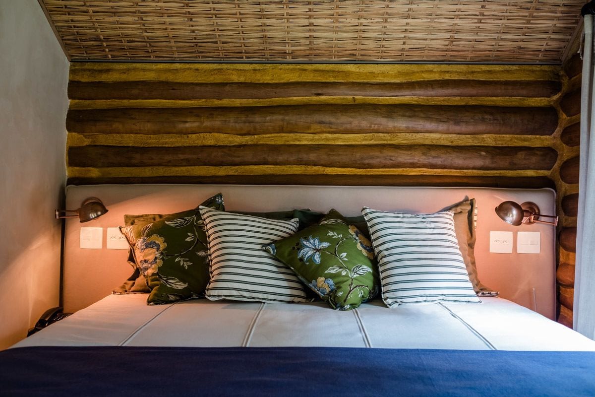 A bed with a wooden headboard, multiple pillows, and bedside lamps.