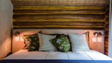 A bed with a wooden headboard, multiple pillows, and bedside lamps.