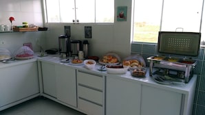 A kitchen counter with various food items and kitchen appliances. - Pousada Porto de Galinhas (Ipojuca)