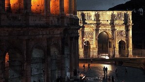 A historic stone archway with intricate carvings and a well-lit facade. - My Suites Piazza di Spagna (Rome)