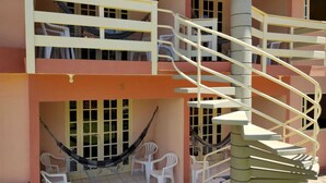 A multi-level building with a spiral staircase, outdoor seating area with chairs, and a hammock. - Recanto Sonhos do Porto (Ipojuca)