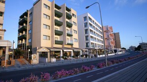 Een modern hotel met meerdere verdiepingen, balkons en een overdekt terras.