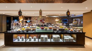 Een buffet met diverse gerechten en een toonbank volgestapeld met borden.