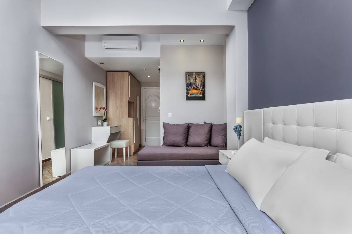 Una camera da letto moderna con un letto grande, una scrivania e un divano.