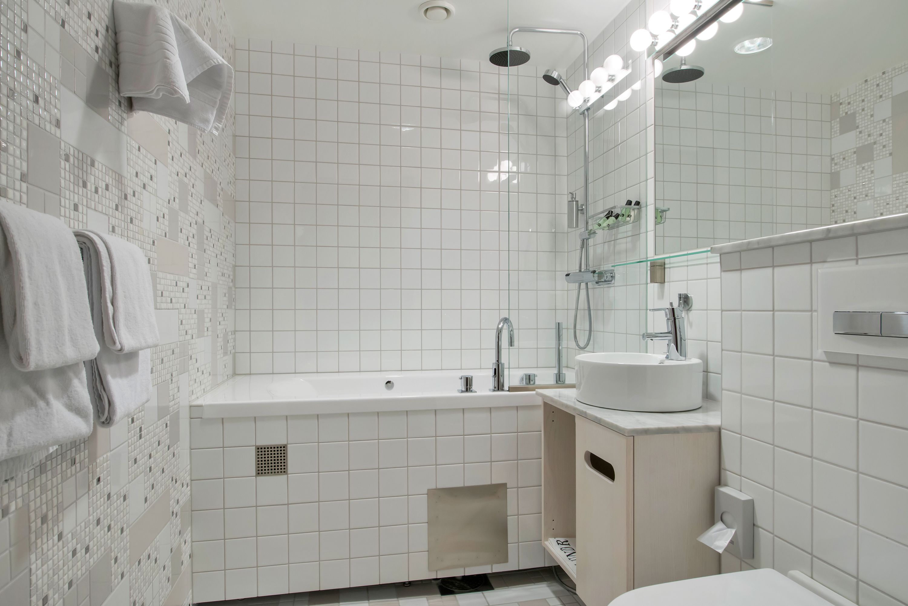 Un baño moderno con una bañera grande, un lavabo y un espejo.