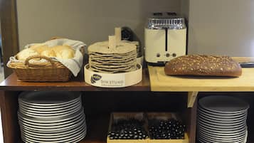Eine Küchenarbeitsplatte mit Brot, einem Toaster und gestapelten Tellern.