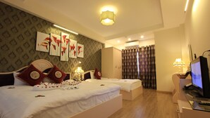 A hotel room with a large bed, a TV, and a desk.