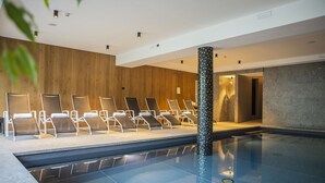 A swimming pool area with lounge chairs and a decorative pillar. - Villa Imperina (Agordo)