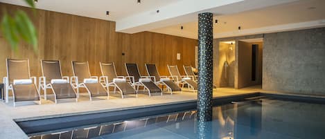 Ein Poolbereich mit Liegestühlen und einer Zierensäule.