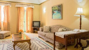 A living room with a sofa, a coffee table, a TV, and a lamp. - Starlight Chalet (Silver Hill Gap)