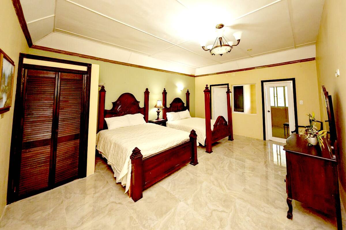 Un dormitorio con dos camas de madera, un armario de madera, un tocador y un espejo.