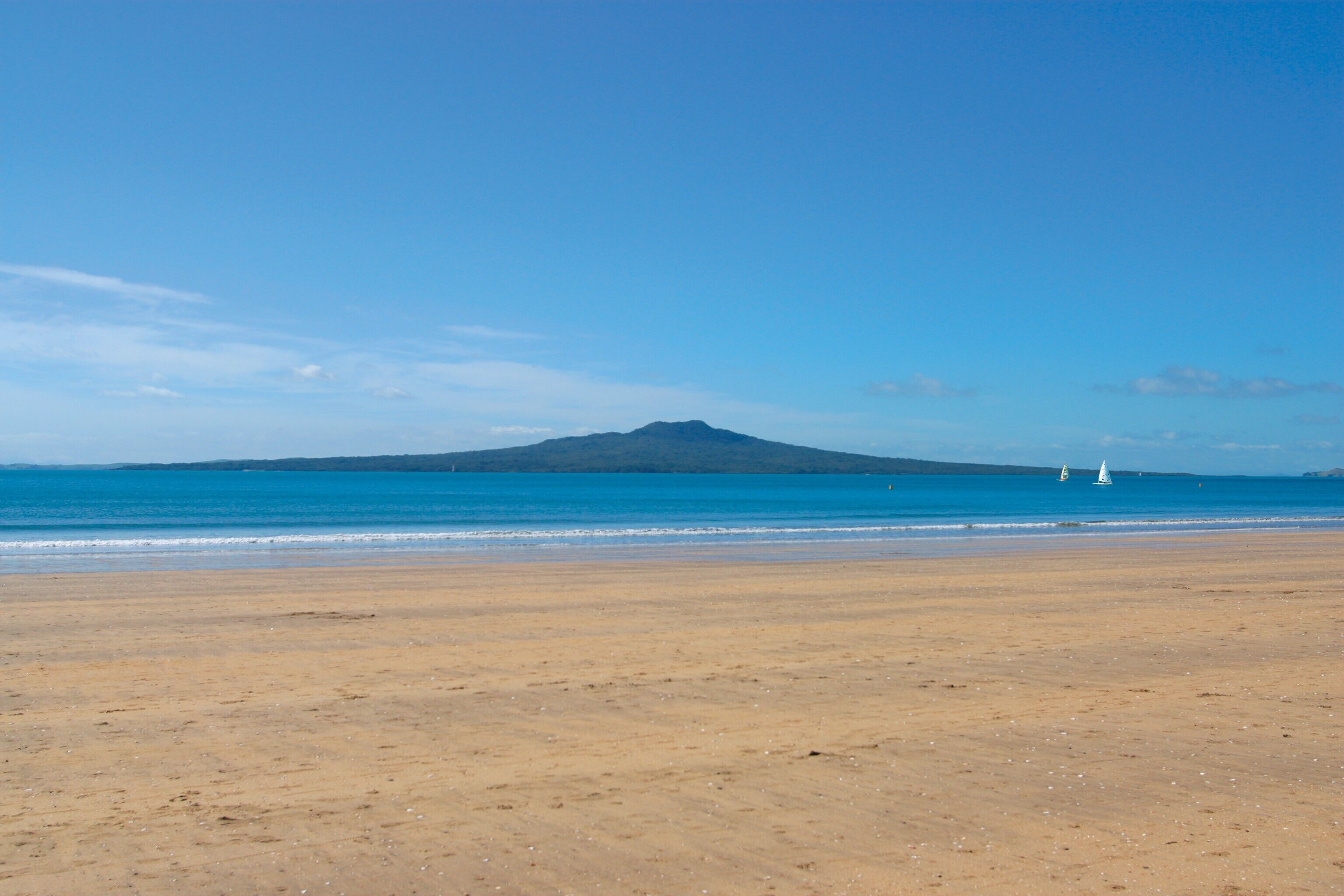 A beach with a mountain in the background.
