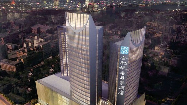Un hotel moderno con due torri imponenti, un'ampia hall e vista sulla città.